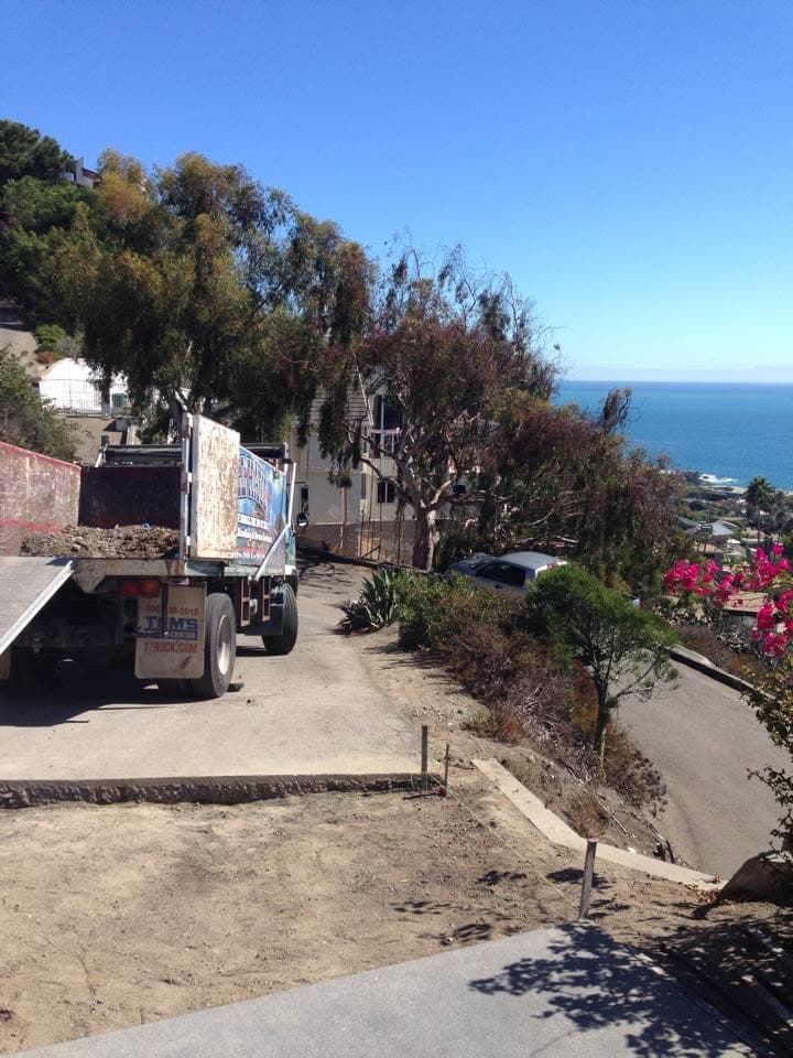 All Haul truck on a hillside street with the Pacific Ocean in the background