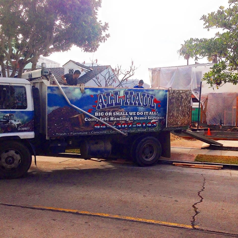 Crew loading the truck curbside near a home under renovation