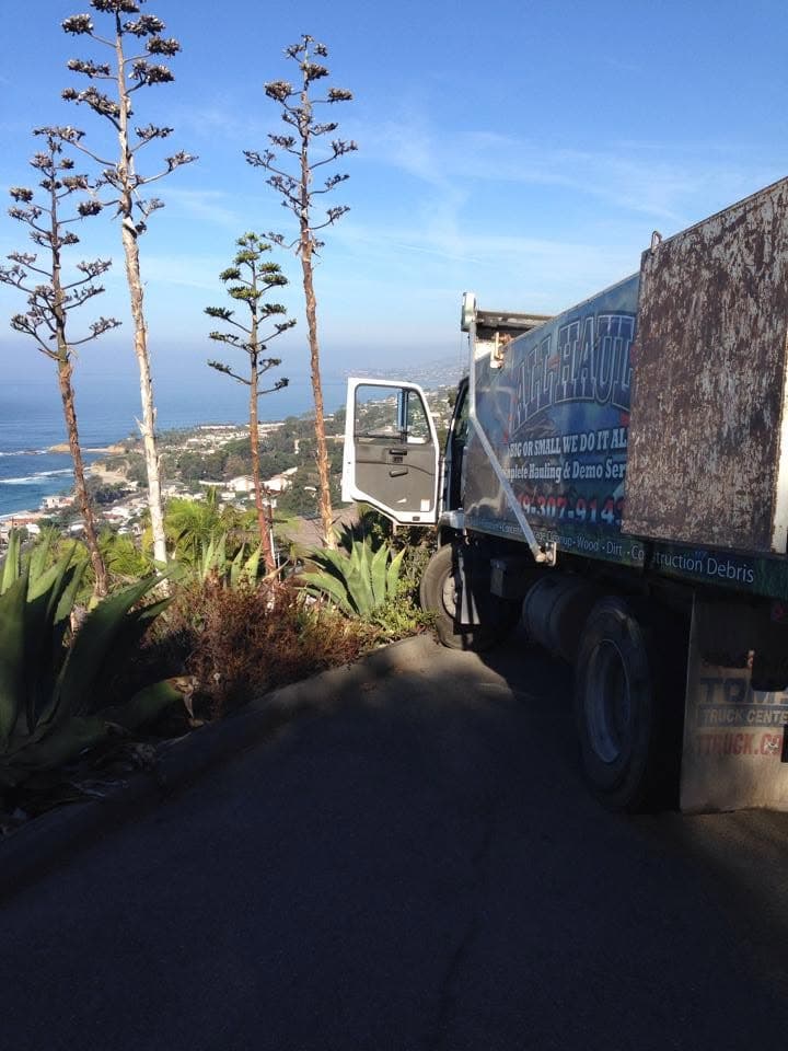 All Haul truck parked on a steep hillside road above the coastline