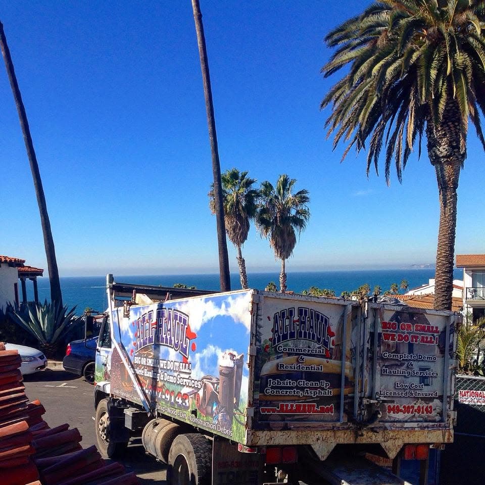 All Haul truck loaded with old roof tile, ocean view in the background