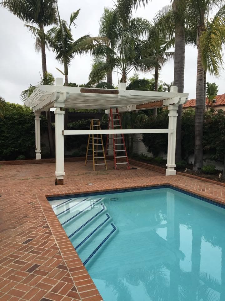 Patio cover being removed next to a backyard pool