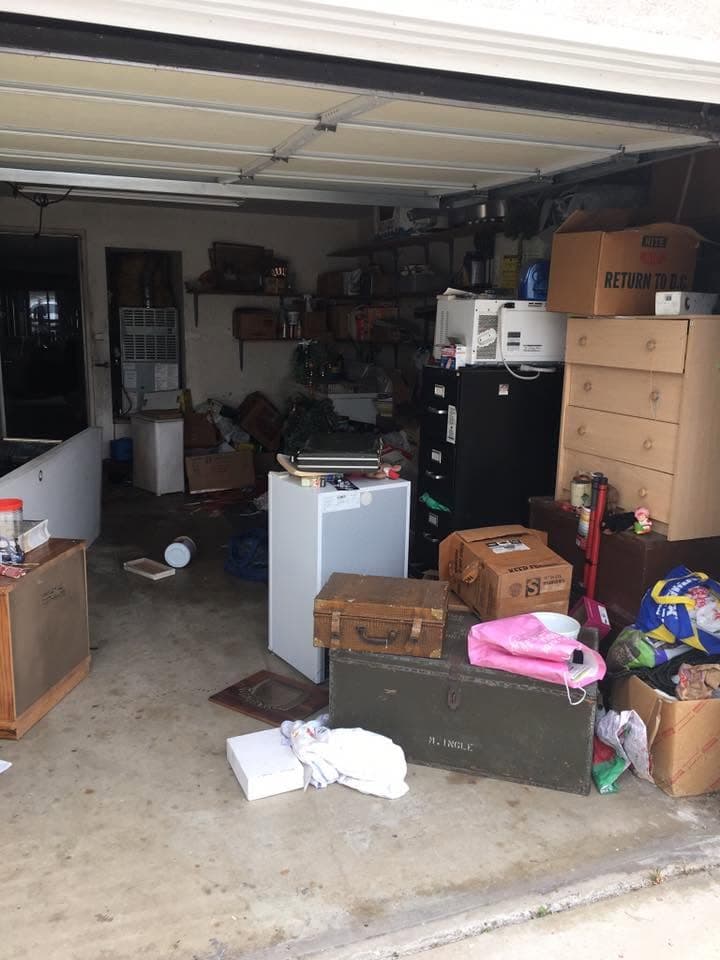 Garage full of boxes and old furniture before a cleanout