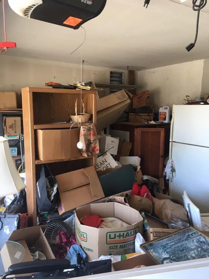 Cluttered garage packed with moving boxes before a cleanout